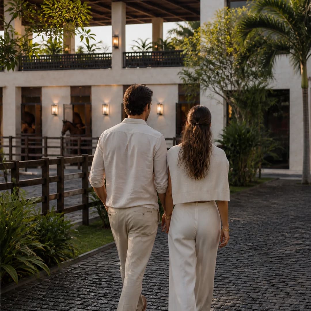 Vista conceptual de una pareja llegando al club por un patio ajardinado.